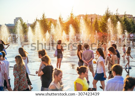MOSCOW, RUSSIA - AUGUST 9, 2015: Young people enjoy the sunset at fountains in Muzeon park at sunset in Moscow, Russia.