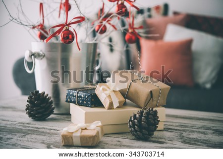 Christmas or new year decoration on modern wooden coffee table. Cozy sofa with pillows on a background. Living room interior and holiday home decor concept. Toned picture