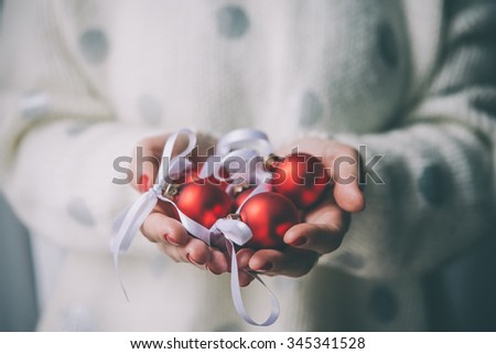 Woman\'s hands hold christmas tree glass balls. Holiday gift and decoration concept. Toned picture
