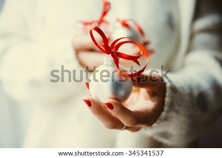 Woman\'s hands hold christmas tree glass balls. Holiday gift and decoration concept. Toned picture