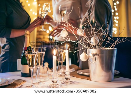 Christmas or New Year party table with champagne. Three persons stand behind