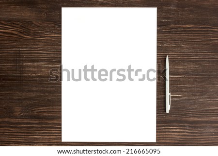 Pen and white card on wooden desk/ Pen and white card on wooden desk