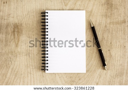 Pen and Notepad on the wooden desk./ Pen and Notepad on the wooden desk