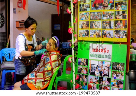 Pataya, Thailand - Dec 2012 - An alternative facial beauty service on street is interested by low-budget women. This service is a facial hair removal with ancient Chinese traditional method