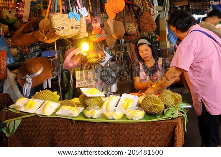 Bangkok - circa June 2014 - An unidentified merchant sells durian, a kind of Thai fruit, to her customer at JJ Market, Bangkok