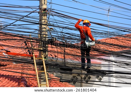 Pattaya, Thailand - Mar 9, 2015 - An unidentified man works on electric wires to install the household cable wires network