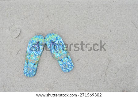 nice sandals on the sand beach texture with a little space on the right for adding text