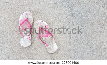 pink beach sandals on sand beach background with space for adding text