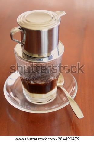 \'Phin\' traditional Vietnamese coffee maker, place on the top of glass, add ground coffee then pour hot water and wait until the coffee dripping into the glass with condensed milk at the bottom