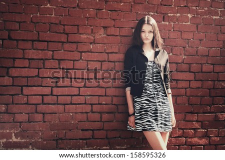 beautiful girl near red brick wall portrait
