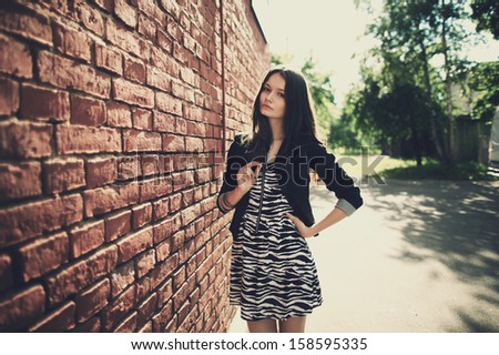 beautiful girl near red brick wall portrait