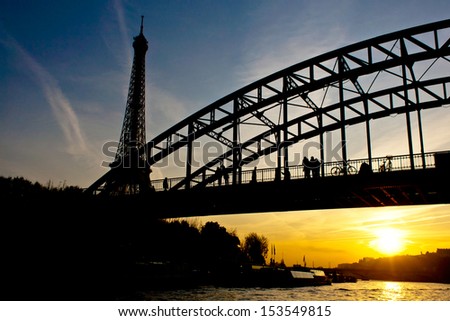 Silhouette of Eiffel tower and a bridge in Paris France at sunset from seine river