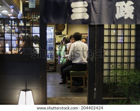 TOKYO, JAPAN - OCTOBER 12: Japanese businessmen eat and drink on a local restaurant on the narrow backstreet alleys around Shinjuku train station in Tokyo, Japan, on October 12, 2012.