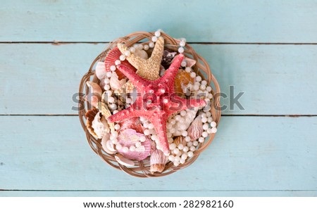 Basket with seashells on blue wooden floor. Decorative composition in marine style