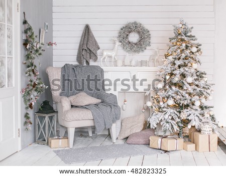 Stylish Christmas interior decorated in gray colors. Comfort home. Armchair with fabric upholstery