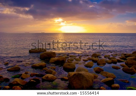 sun rises over Dublin Bay as ships pass on horizon