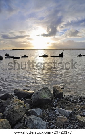 foreground rocks and evening sunlight show peaceful scene at Lough Conn, Co.Mayo, Ireland