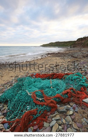 fishing nets,stones and debris, washed ashore on beach in Co.Cork, Ireland