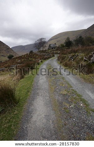 gravel road leading past direlict house in heart of Kerry Mountains, Co.Kerry, Ireland