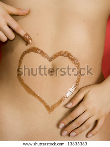 chocolate heart drawn on the belly of a woman