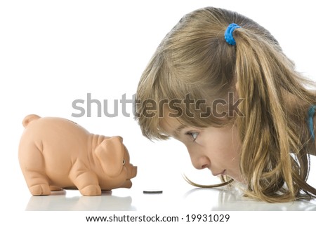 little girl depositing change in her piggy bank