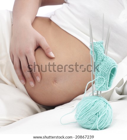 young mothers sits at home relaxing knitting for her new baby