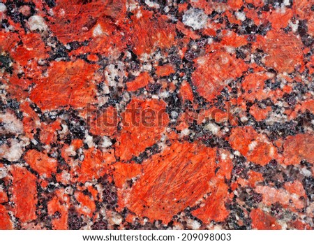 Texture of granite with a bright red, black and white patches