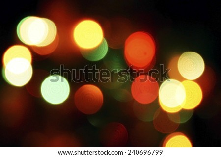Round bright red, yellow and green spots on a dark background bokeh