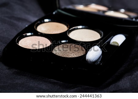 Set of four round eye shadow in a black plastic box