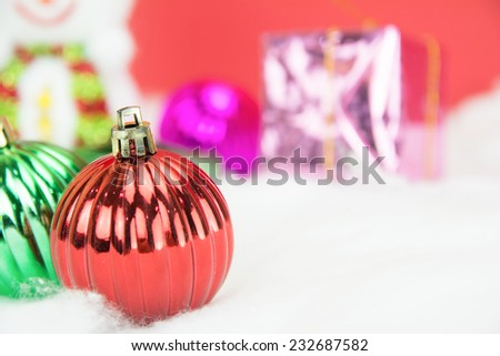 Red christmas balls and Snow man with gift on white snow on red background, concept christmas