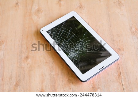 Smartphone with broken screen on wood background