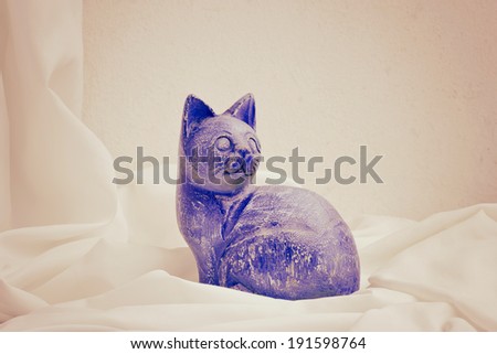 A handmade wooden sculpture of cat painted by hand. Still life.