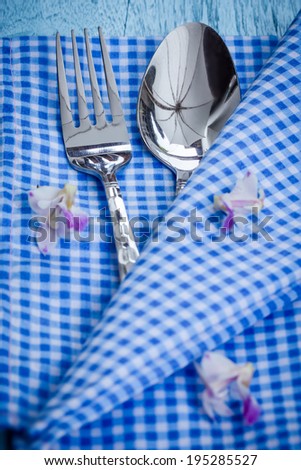 Silverware at napkin on wooden background