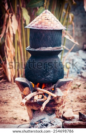 Pot boiling water for cooking sticky rice on the fired stove