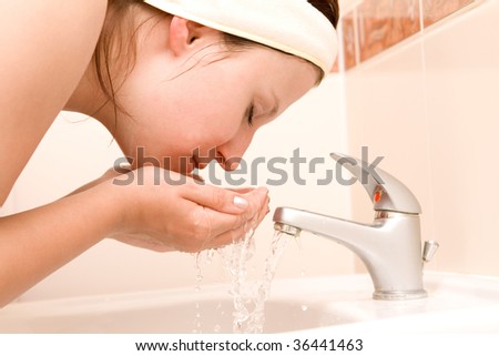 Woman cleaning face in bathroom
