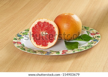 Plate of red grapefruits on the table