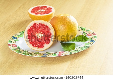 Plate of red grapefruits on the table