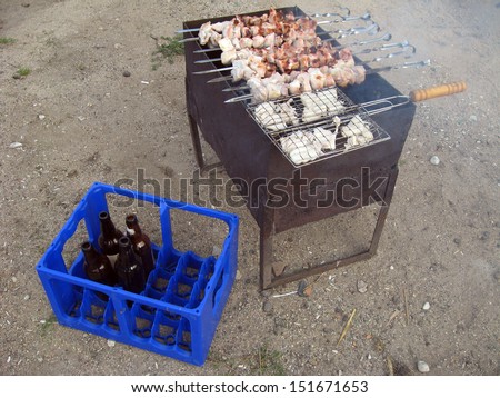 Meat on grill and beer bottles in box