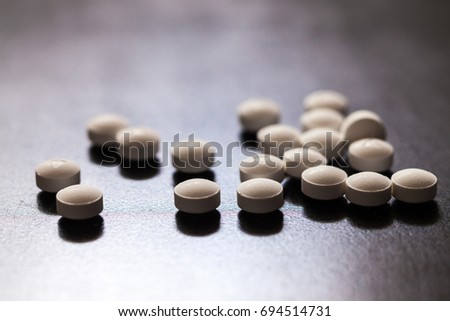 Backlit white pills - Opioid and prescription medication addiction epidemic or crisis - concept