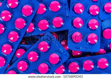 Full frame of pile of ibuprofen in pink tablet pills pack in blue blister packaging. Ibuprofen for relief pain, headache, high fever and anti inflammatory. Painkiller tablets pills.