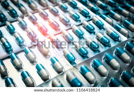 Blue and white capsules pill in blister pack arranged with beautiful pattern. Global healthcare concept. Antibiotics drug resistance. Antimicrobial capsule pills. Pharmaceutical industry.