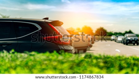 SUV Car parked on concrete parking area at factory near the sea with blue sky and clouds. Car dealership. Car stock for sale. Car factory parking lot. Automotive Industry. Used automobile business.