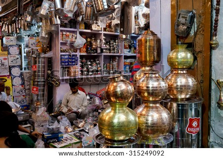 Jaipur, India; 2nd Nov 2013: Metal items and utensils shop with the store owner sitting. These metal retailers and manufacturers do brisk business on the hindu festival of Dhanteras