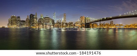 The Manhattan skyline in New York City at night including the new One World Trade Center and Brooklyn Bridge.
