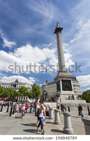 LONDON - AUGUST 20: Nelson\'s Column at Trafalgar Square in London with blue sky and tourists passing by on August 20, 2013