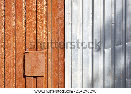 Rusty and brand new corrugated iron sheets.