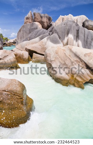 Granite rock formation and turquoise water at Anse Cocos in La Digue, Seychelles