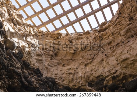 An old cave covered with a wooden grid to protect people from falling into it. Seen in Ajuy in Fuerteventura, Spain.