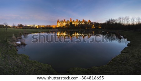 Panorama of the University Hospital (Uniklinik) Aachen at night with reflection in a small lake. The hospital is one of the biggest in Europe and looks rather like an industrial plant.