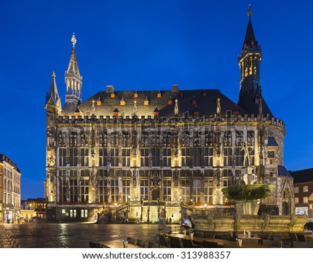 The historic town hall of Aachen, Germany with night blue sky and the Karlsbrunnen in the foreground. Taken with a shift lens.